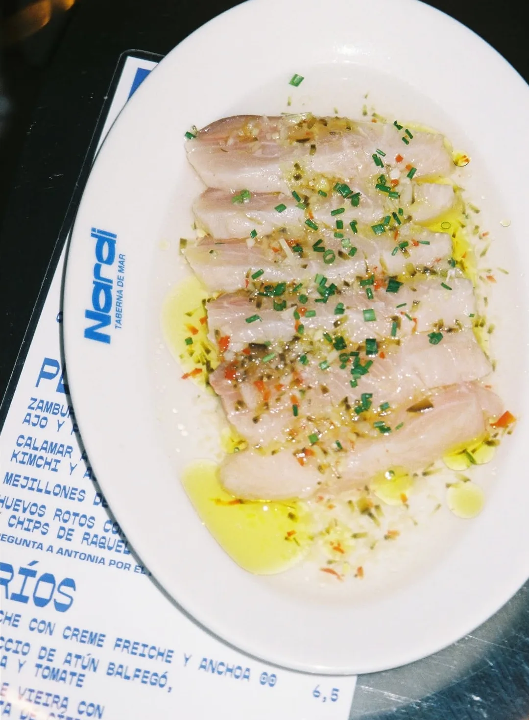 Láminas de pescado blanco crudo con aceite, cebollino y vinagreta, sobre la carta de Nardi