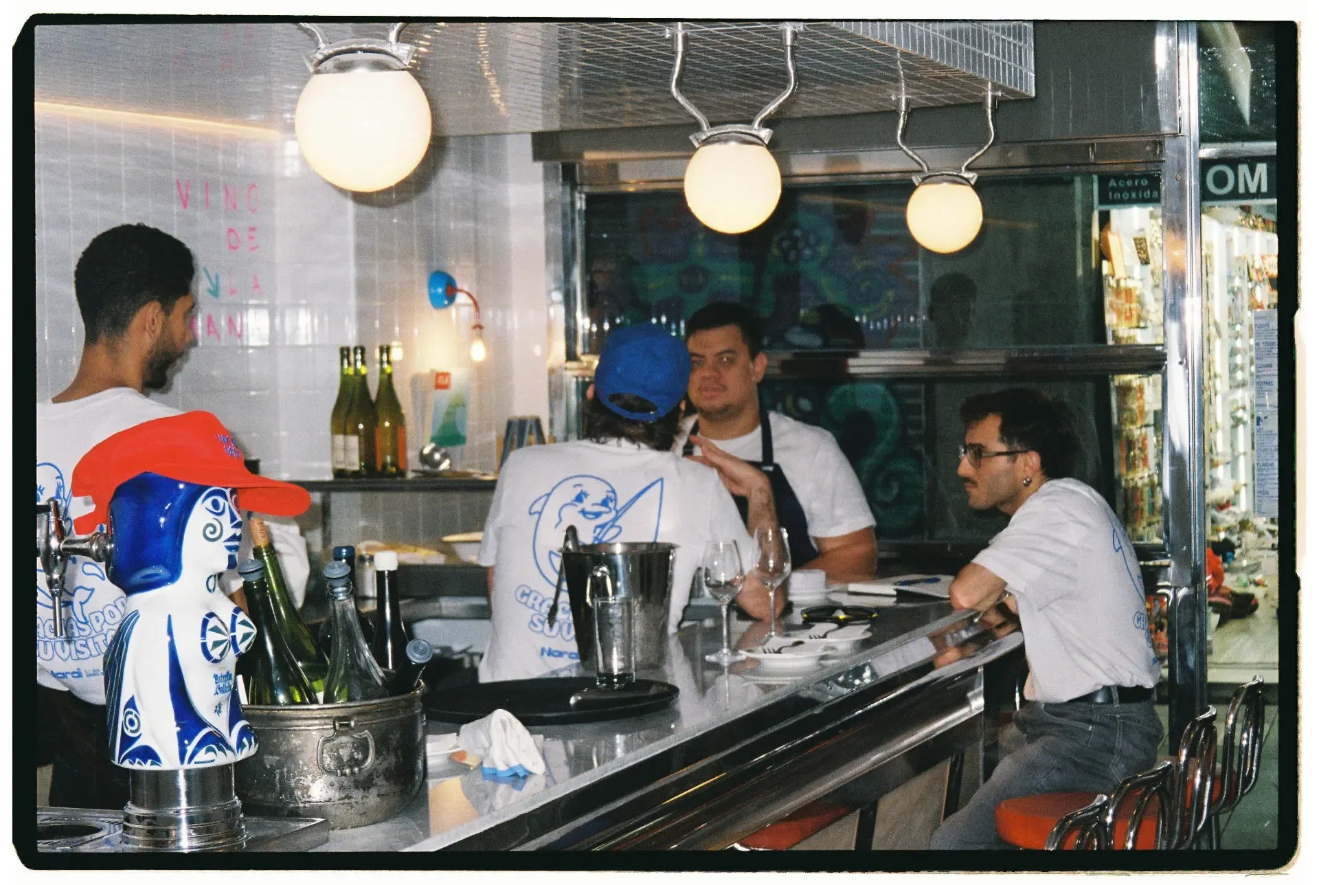 Área de bar con empleados detrás de la barra conversando en Taberna Nardi, Barcelona